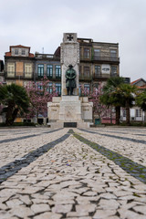Memorial to the people from Porto that died in the first great war. Iron soldier statue. Trees in flower and colorful buildings. Porto