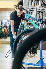 Fototapeta na wymiar Guy is repairing a bicycle in a bicycle workshop