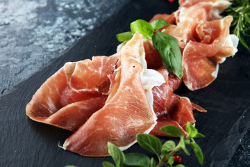 Italian prosciutto crudo or jamon with rosemary. Raw ham appetizer