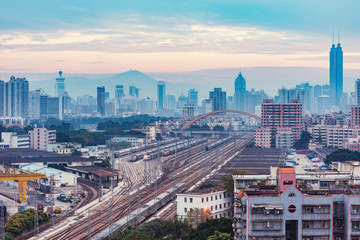 Cityscape and railway station at evening time.