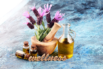 lavender herbal oil and lavender flowers. bottle of lavender massage oil for aromatherapy treatment and wellness letters made of wood - obrazy, fototapety, plakaty