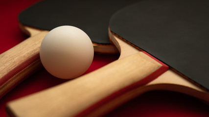 a pair of ping pong paddles with a ball
