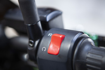 Macro detail of red stop engine button and gas handle of the motorcycle