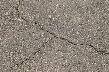 Obraz premium The cracked gray asphalt background