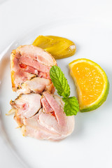 Stuffed chicken rolls on a white plate with mustard