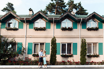 Hugging happy couple in summer casual stylish clothes on the background of a colorful house in the Italian style