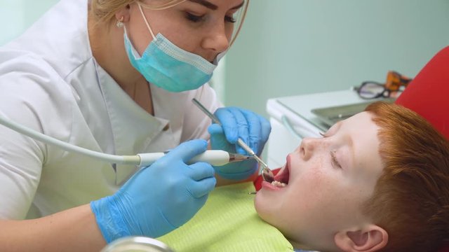 Closeup of female dentist treating little boy in dental clinic