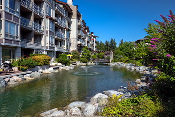 Apartment buildings in North Vancouver. Beautiful facade with a pond and a fountain in the courtyard of a residential complex