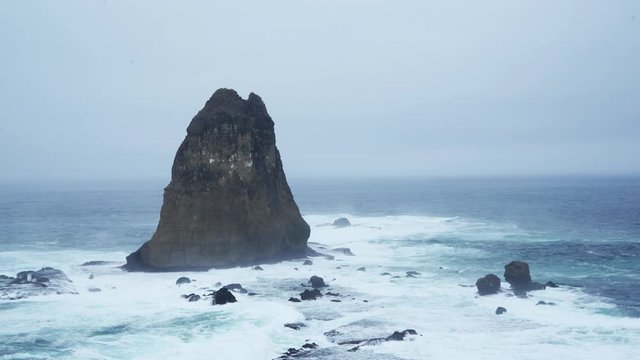 Beautiful scenery of Papuma beach with frothy waves and coral at misty morning, Jember, East Java, Indonesia. Shot in 4k resolution