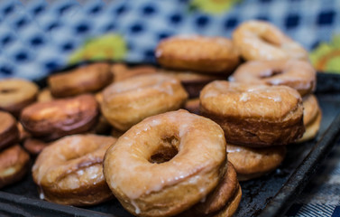 homemade glazed donuts on a black platter