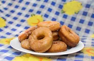 homemade glazed donuts, on a white plate in the foreground