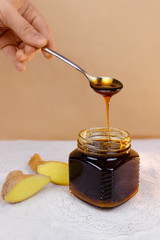 Buckwheat honey pours from spoon into jar