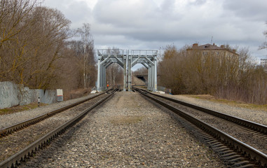 Fototapeta na wymiar The railway tracks lead to the bridge.Old rails in landscape
