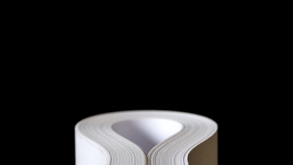 Multiple sheets of rolled A4 paper (ream) on black background. Simple, isolated object with copy space perfect for illustrating various concepts. Selective focus (shallow DOF).