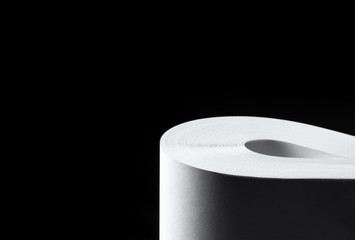 Multiple sheets of rolled A4 paper (ream) on black background. Simple, isolated object with copy space perfect for illustrating various concepts. Selective focus (shallow DOF).