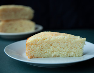 A piece of pie on a white plate on the table. On dark background