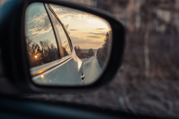 Fototapeta premium Reflection of the road in the mirror of a car closeup.