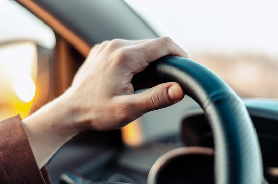 Closeup guy hand on car steering wheel