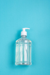 Container with alcohol gel on the light blue background