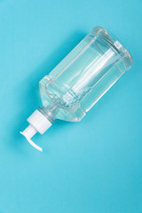 Container with alcohol gel on the light blue background