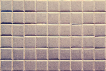 Background of a square rough tile with uneven edges, close-up