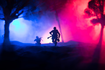 Plakat War Concept. Military silhouettes fighting scene on war fog sky background, World War Soldiers Silhouette Below Cloudy Skyline At night.