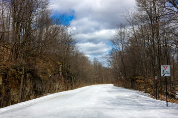Obraz premium Chelsea snowy closed road for cars in April Gatineau park Quebec Canada