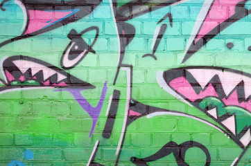 Abstract colorful fragment of graffiti paintings on old brick wall in pink and green colors. Street...