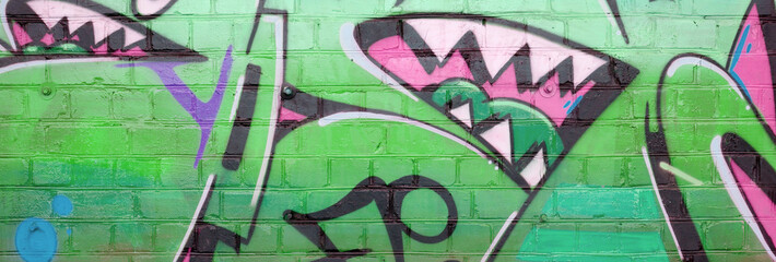 Abstract colorful fragment of graffiti paintings on old brick wall in green colors. Street art...