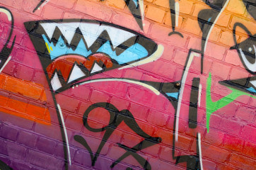 Abstract colorful fragment of graffiti paintings on old brick wall. Street art composition with...