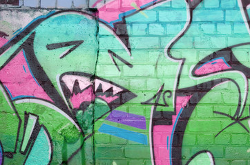 Abstract colorful fragment of graffiti paintings on old brick wall in pink and green colors. Street...