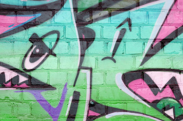 Abstract colorful fragment of graffiti paintings on old brick wall in green colors. Street art...