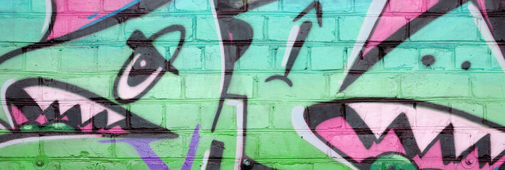 Abstract colorful fragment of graffiti paintings on old brick wall in green colors. Street art...