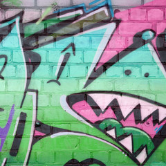 Abstract colorful fragment of graffiti paintings on old brick wall in green colors. Street art...