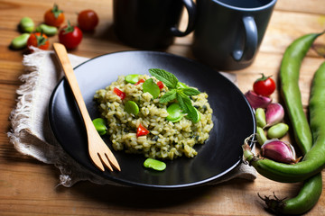 Italian risotto with broad beans, cherry tomato and mint - vegetarian food - Italian cuisine - closeup