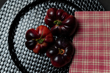 Tomatoes on black plate and napkin