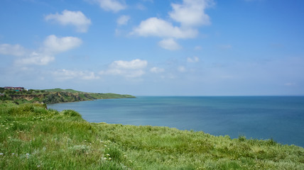 Fototapeta na wymiar Seascape with a rocky coastline in green grass