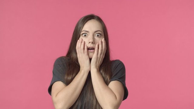 Shocked, speechless caucasian woman, gasping, shut mouth with hands, looking around if someone also saw it, react to shook scary accident, gossiping, found out dirty little secret, pink background