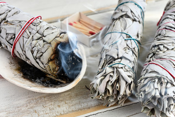 A close up image of a burning white sage smudge stick used for energy clearing and healing. 
