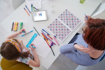 Mother and little daughter  playing together  drawing creative artwork