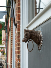 Old Antique Vntage Metal Horse Head and Ring attached to wall of building.