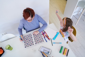 Mother and little daughter  playing together  drawing creative artwork