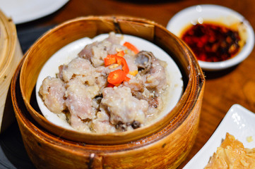 Delicious Chinese Steamed Pork Ribs in a Steamer with Chili Oil aside.