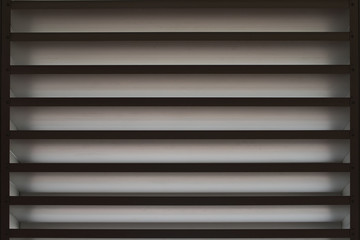 Obraz premium A beautiful, dark and mysterious background image of the vents where some light shines, creating shadows and with both bright and dark parts.