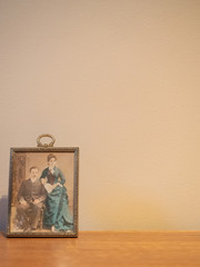 1800s Framed Portrait of a Couple with the woman wearing a long dress in turquoise. Image has copy space.