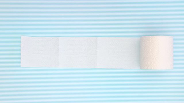 Toilet paper rolling on blue background - Stop motion 