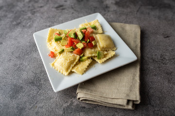 Creative cheese ravioli topped with fresh tomato and avocado and seasoning.  Italian ravioli with a twist. 