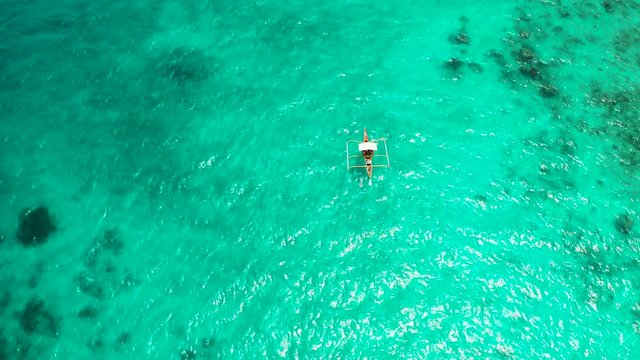 Motor boat on the surface of the lagoon with turquoise water, top view. Summer and travel vacation concept.