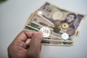 hand hold a Japanese currency yen coin and yen bank note white background.