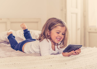 COVID-19 Lockdown. Little girl using mobile video calling or e-learning during coronavirus outbreak
